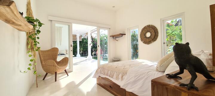 Bedroom with rattan armchair and glass doors to the terrace