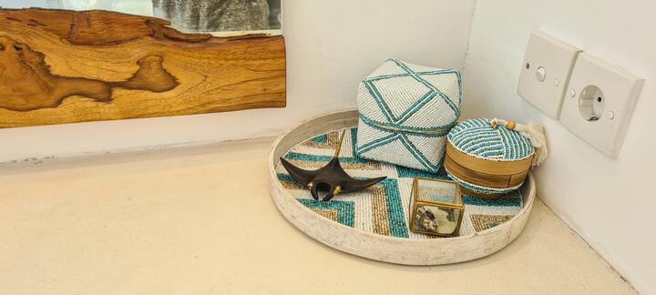 Woven tray with turquoise boxes on a teak bench